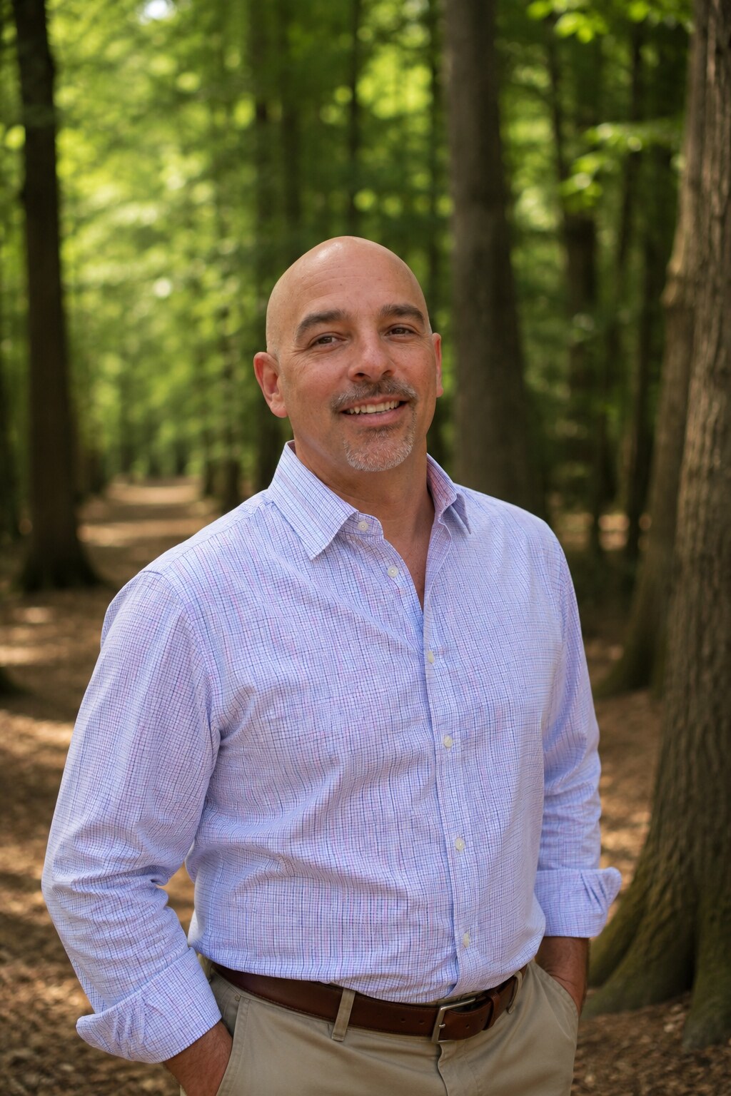 Kevin Hartke, principal consulting arborist, standing among mature trees